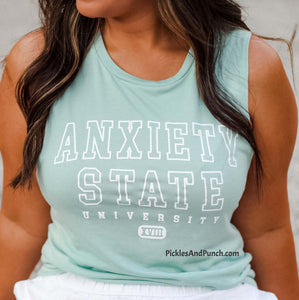 Anxiety State University muscle tank dusty blue  65/35 polyester/viscose Fit: Relaxed, Drapey, flowy, Muscle Style: Low cut armholes, curved bottom hem Shirt Color: Dusty Blue muscle